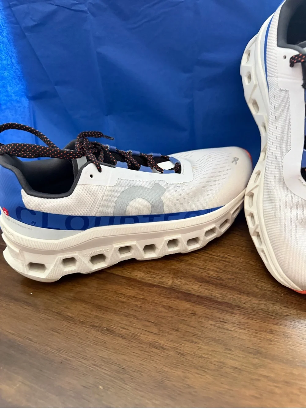 On Running Gray Sneakers with Blue Accents and Black/Orange Laces